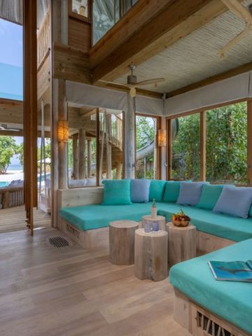 Moderne Lounge mit Blick auf Pool und Garten im Soneva Jani Hotel