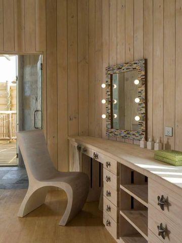 Holzverkleideter Raum mit Sitz und beleuchtetem Spiegel