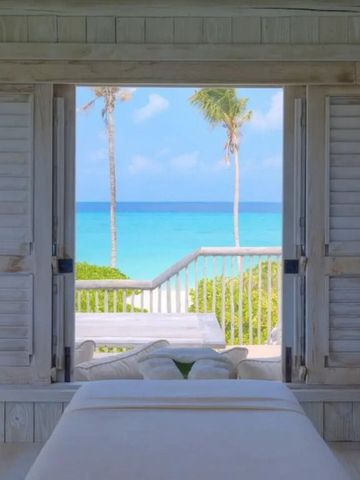 Offenes Zimmer mit Blick auf das blaue Meer und Palmen
