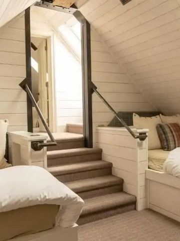 Gemütlicher Dachbodenraum mit zwei Einzelbetten und hellem Holzdesign