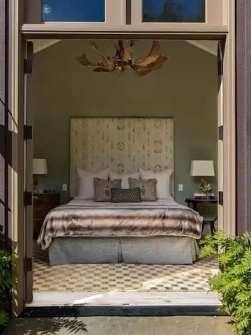 Elegantes Schlafzimmer mit offener Tür zur Terrasse und stilvollem Bett