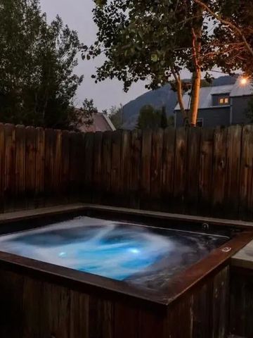 Freistehender Whirlpool im Garten mit Bergblick und abendlicher Beleuchtung