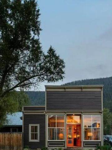 Außenansicht des Hotels bei Abenddämmerung mit großen Fenstern