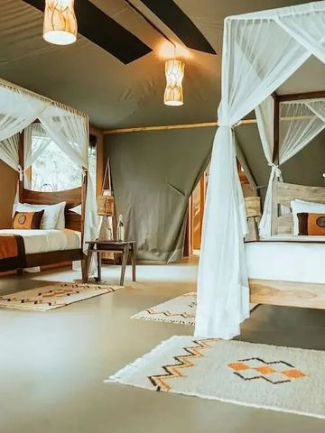 Geräumiges Schlafzimmer mit zwei Himmelbetten und stilvollem Dekor