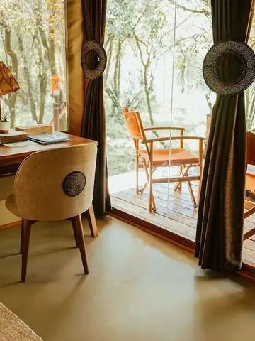 Heller Raum mit Schreibtisch Blick auf Terrasse und Wald