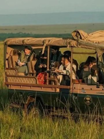 Safarifahrzeug auf einer Tour durch die Savanne mit Reisenden