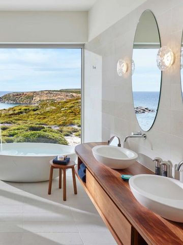 Luxuriöses Badezimmer mit Meerblick und freistehender Badewanne