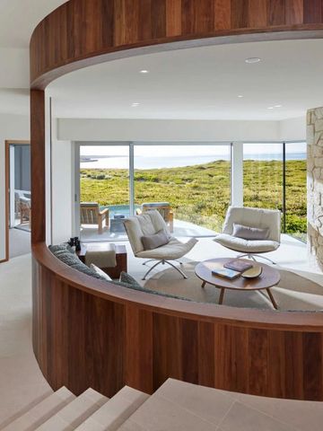 Geräumiges Wohnzimmer mit großen Fenstern und eleganter Einrichtung