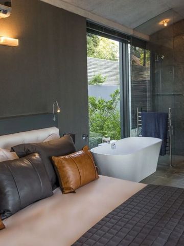 Luxuriöses Schlafzimmer mit modernem Design und Badezimmer mit Blick ins Grüne