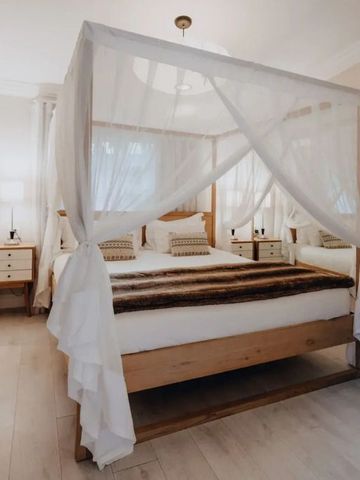 Helles Schlafzimmer mit Himmelbett und Holzdetails