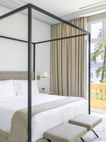 Elegantes Hotelzimmer mit Himmelbett und Balkonblick