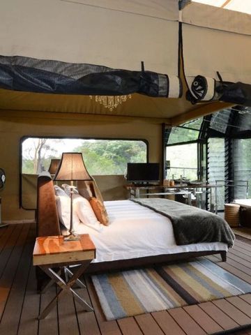 Stilvolles Zeltzimmer mit Holzakzenten und freiem Blick auf Natur