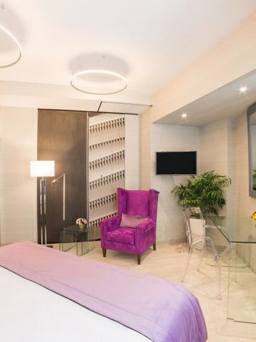 Elegantes Zimmer mit violettem Sessel und Glasdetails