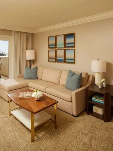 Sitzbereich mit Sofa und Zugang zu einem sonnigen Balkon