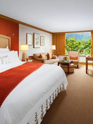 Geräumiges Hotelzimmer mit großem Bett und Panoramablick.