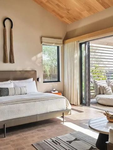 Luxuriöses Schlafzimmer mit Kingsize-Bett und Zugang zur Terrasse mit Gartenblick