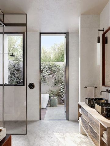 Modernes Badezimmer mit Glasdusche und Blick in einen begrünten Innenhof