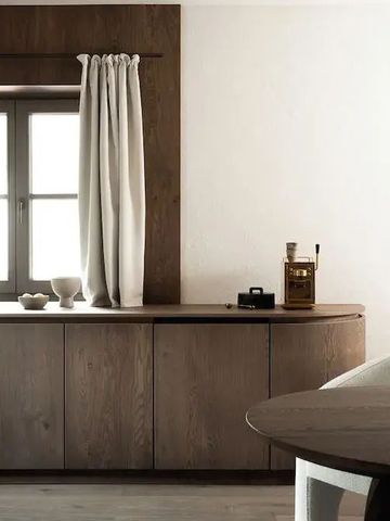 Heller Raum mit Holzschrank und dekorativen Details nahe einem Fenster