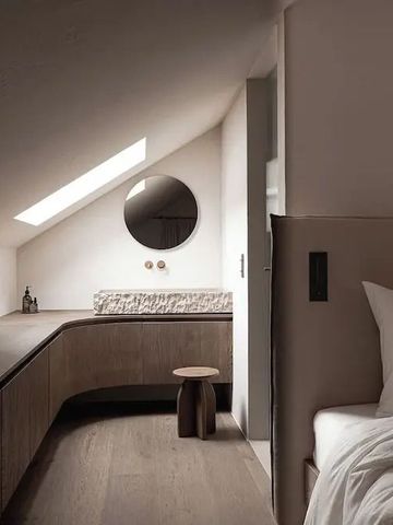 Gemütliches Zimmer unter dem Dach mit stilvoller Einrichtung und großem Spiegel.