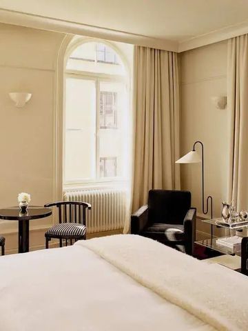 Gemütliches Hotelzimmer mit Sitzecke und großen Fenstern.