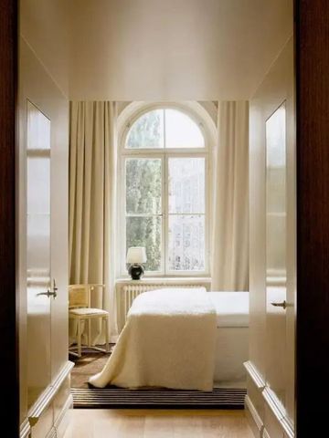 Helles Hotelzimmer mit großem Fenster und zeitgenössischem Dekor.