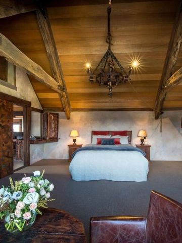 Luxuriöses Schlafzimmer in Holzausstattung mit Blumen auf dem Tisch