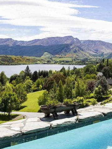 Pool mit Blick auf malerische Berge und einen See bei Sonnenschein