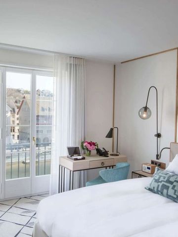 Helles Hotelzimmer mit Balkonblick auf die Altstadt von Zürich