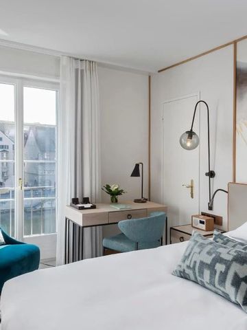 Helles Gästezimmer mit Sitzbereich und Blick auf den Zürichsee