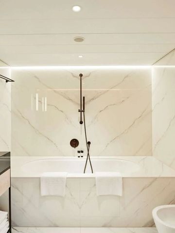 Modernes Badezimmer mit Marmordekor und komfortabler Badewanne