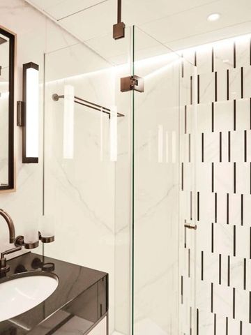 Elegantes Badezimmer mit Glasdusche und stilvollen Armaturen