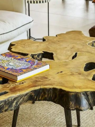 Einzigartiger Couchtisch aus Holz mit dekorativem Buch in einer stilvollen Lounge