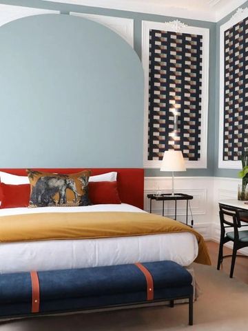 Helles Zimmer mit farblich abgestimmtem Dekor und großem Bett