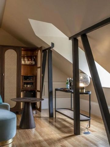 Charmante Sitzecke in einem eleganten Dachzimmer mit Schrägwände und Holzboden