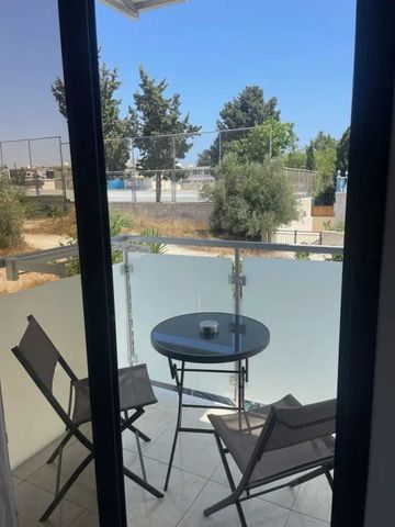 Kleiner Balkon mit Sitzgelegenheiten und Blick auf umliegende Bäume