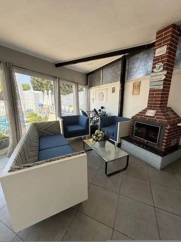 Gemütliche Lounge mit Kamin und großen Fenstern zum Garten hin