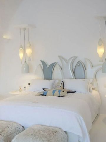 Geschmackvoll gestaltetes Schlafzimmer mit dekorativem Bettkopf und weichen Kissen