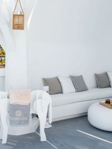 Minimalistische Lounge mit weißem Sofa und Blick auf Früchte und Getränke