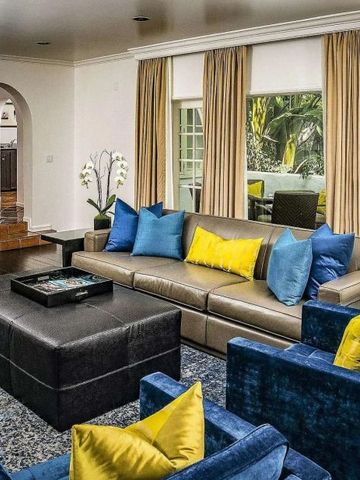 Wohnbereich einer Suite mit Sofa, blauen und gelben Kissen, großen Fenstern