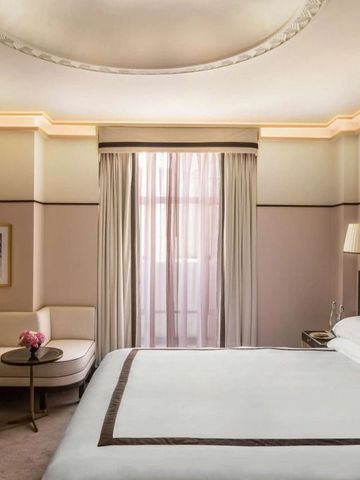 Helles Schlafzimmer mit Kingsize-Bett und eleganter Beleuchtung