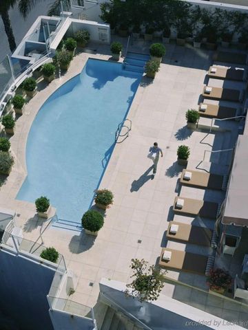 Luftaufnahme eines eleganten Pools mit Sonnenliegen und Pflanzen.