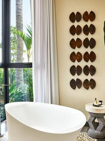 Elegantes Badezimmer mit freistehender Badewanne und dekorativer Wandkunst