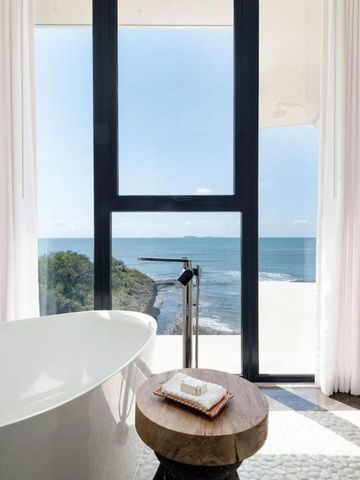 Ausblick vom Badezimmer auf das Meer durch große Fenster