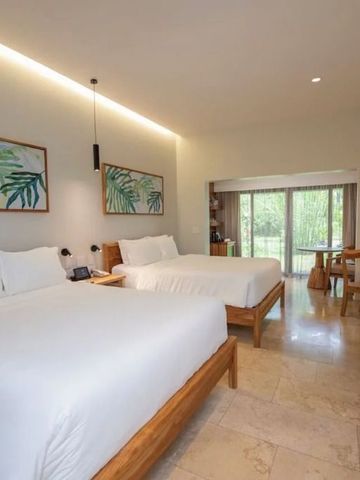 Helles Zimmer mit zwei Betten und Blick auf Natur