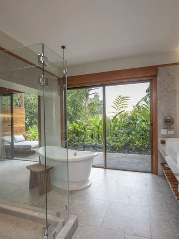 Luxuriöses Badezimmer mit freistehender Badewanne und Gartenblick
