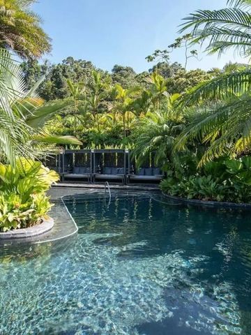 Tropischer Außenpool umgeben von üppiger Vegetation