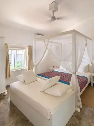 Geräumiges Schlafzimmer mit Himmelbett und minimalistischer Einrichtung