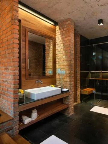 Elegant eingerichtetes Badezimmer mit Backsteinwänden und moderner Ausstattung