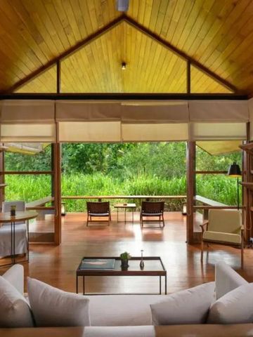 Luxuriöser Wohnbereich mit Holzdach und Blick auf tropische Vegetation