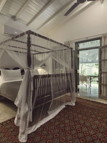 Helles Zimmer mit Himmelbett und Zugang zu einer Terrasse oder Garten